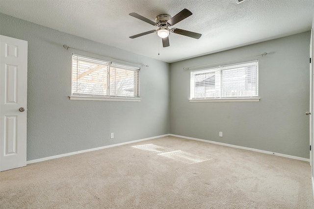 carpeted spare room featuring a textured ceiling and ceiling fan