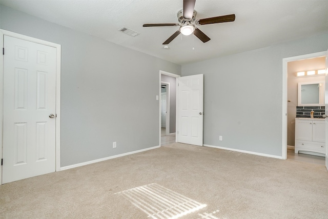 unfurnished bedroom with light carpet, a textured ceiling, and ceiling fan