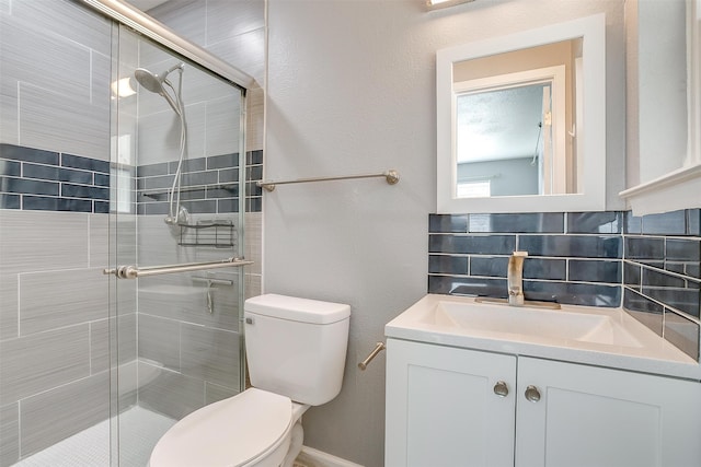 bathroom with toilet, a shower with shower door, tasteful backsplash, and vanity