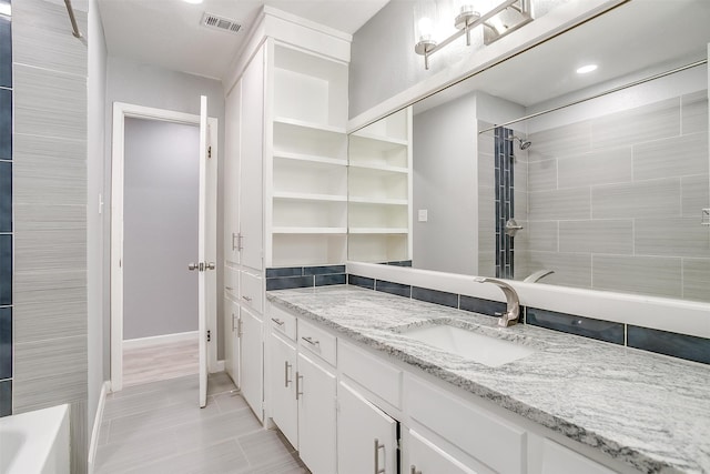 bathroom featuring vanity and tiled shower / bath combo