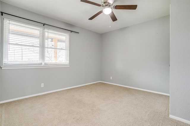 carpeted spare room featuring ceiling fan