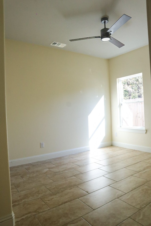 tiled spare room with ceiling fan