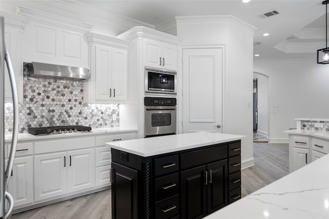 kitchen with ornamental molding, stainless steel appliances, extractor fan, pendant lighting, and white cabinets