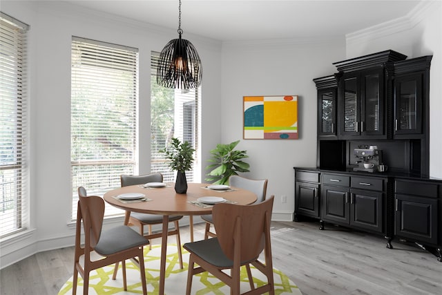 dining room with crown molding, light hardwood / wood-style flooring, and an inviting chandelier