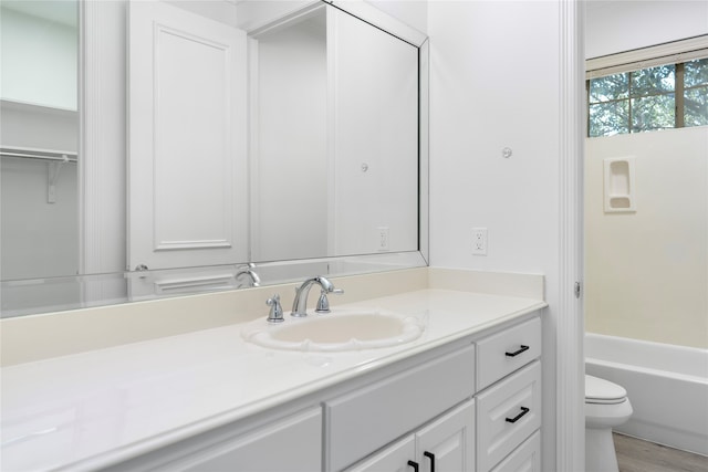 bathroom with wood-type flooring, vanity, and toilet