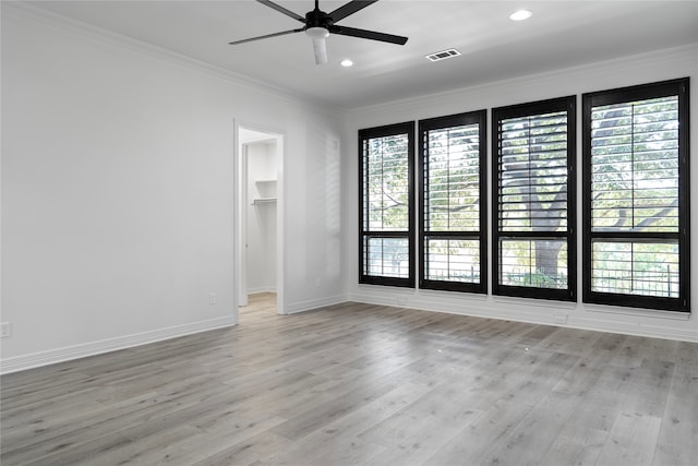 empty room with ceiling fan, crown molding, and light hardwood / wood-style floors