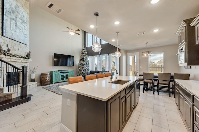 kitchen featuring light countertops, open floor plan, visible vents, and dark brown cabinets