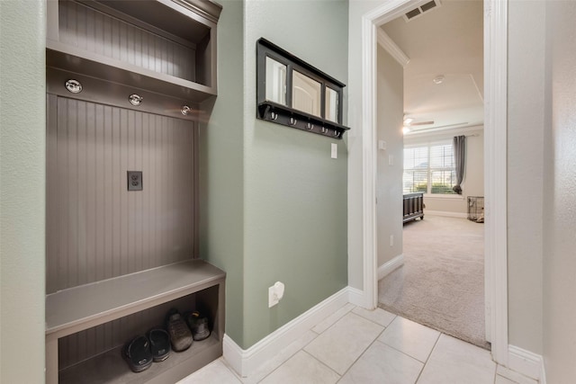 mudroom featuring ceiling fan, light colored carpet, and ornamental molding