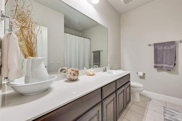 bathroom featuring double vanity, baseboards, visible vents, tile patterned flooring, and a sink