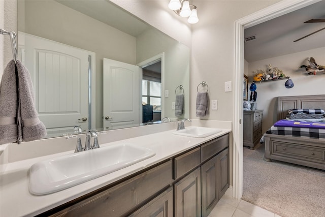 ensuite bathroom featuring double vanity, connected bathroom, visible vents, and a sink