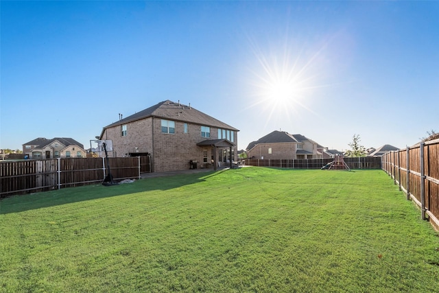 view of yard featuring a fenced backyard, a residential view, and a playground