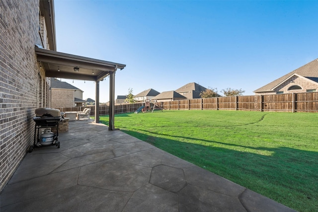 view of yard featuring a patio area, a fenced backyard, and a playground