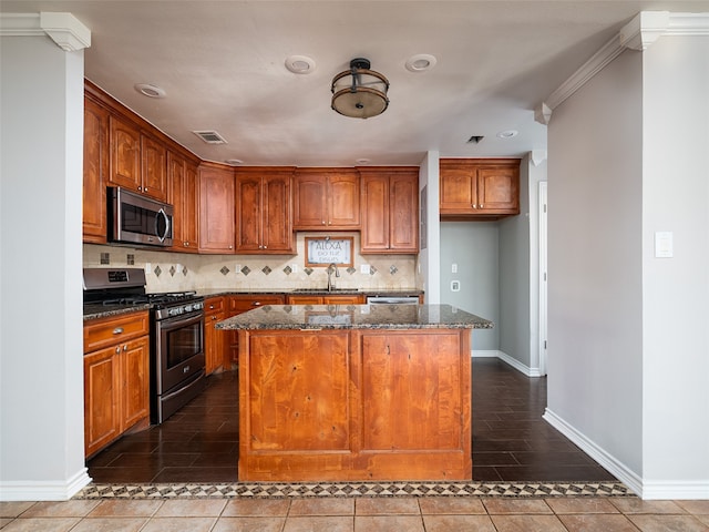 kitchen with a kitchen island, appliances with stainless steel finishes, and dark stone countertops