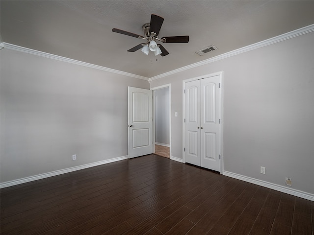 unfurnished bedroom with ceiling fan, a textured ceiling, ornamental molding, dark wood-type flooring, and a closet