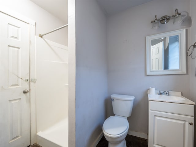 bathroom with vanity, a shower, and toilet