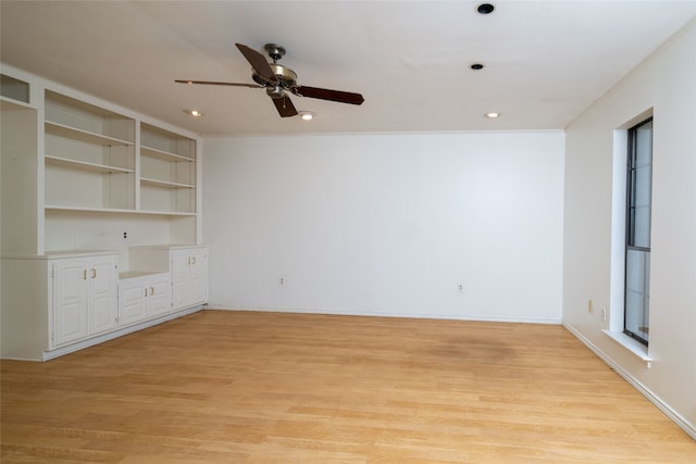 empty room with ceiling fan, ornamental molding, and light hardwood / wood-style flooring