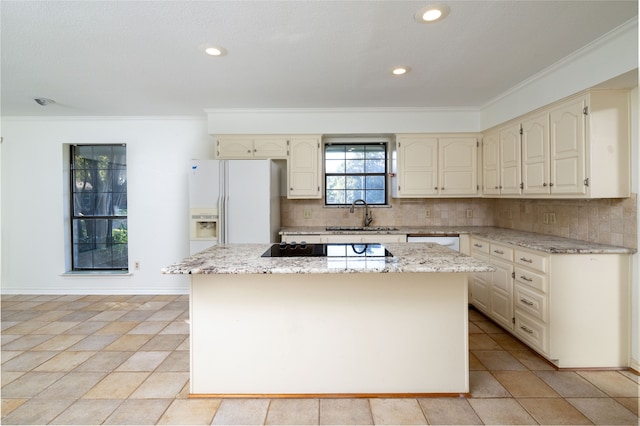 kitchen with white appliances, light stone countertops, sink, a kitchen island, and backsplash