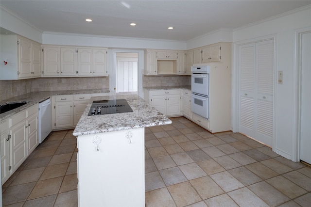 kitchen featuring backsplash, a kitchen island, crown molding, and white appliances