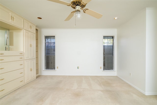 carpeted empty room featuring ceiling fan and ornamental molding