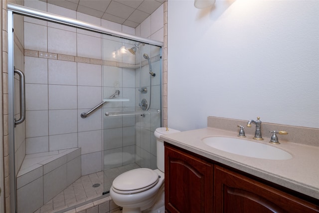 bathroom with vanity, toilet, and a shower with shower door