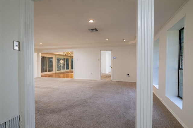 carpeted empty room with ornamental molding and ornate columns