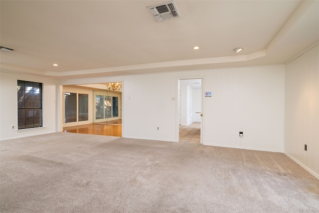 spare room with light carpet and a tray ceiling