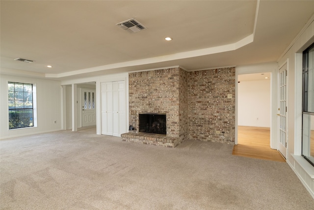 unfurnished living room with a fireplace and light colored carpet