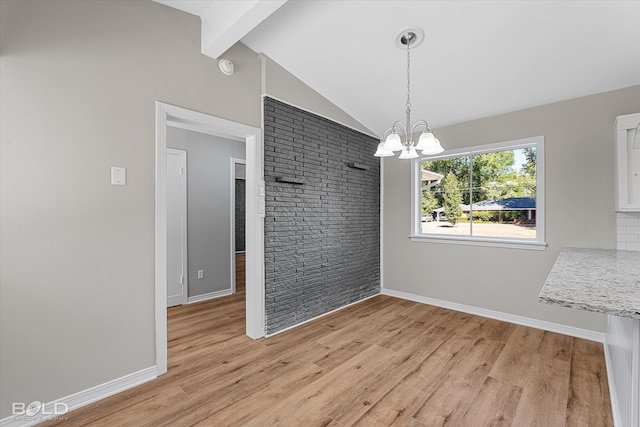 unfurnished dining area with vaulted ceiling with beams, light hardwood / wood-style flooring, brick wall, and an inviting chandelier