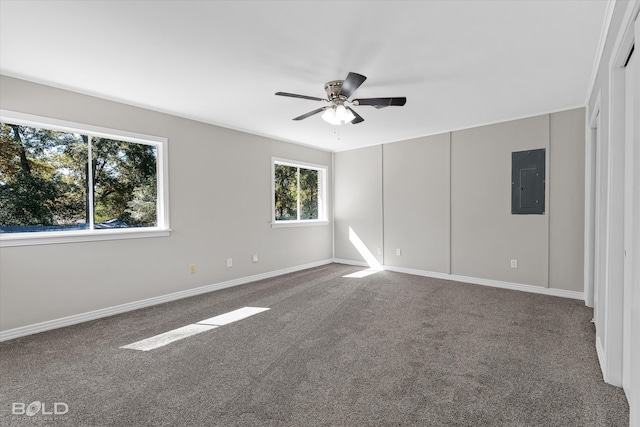 spare room with carpet flooring, electric panel, a wealth of natural light, and ceiling fan