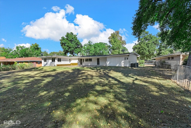 rear view of house featuring a yard and central AC unit