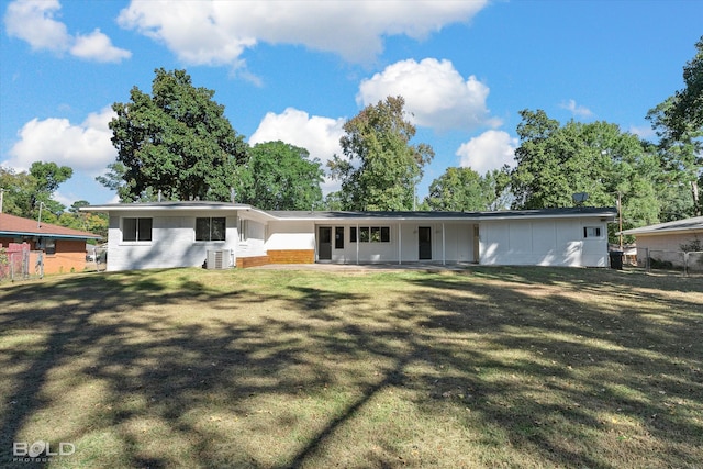 view of front of house with central AC and a front lawn