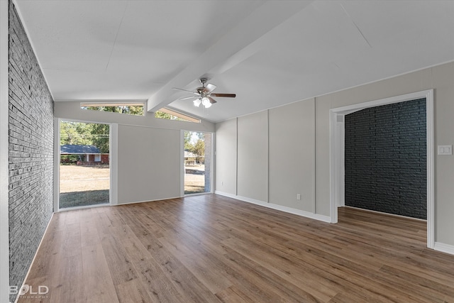 unfurnished room featuring ceiling fan, hardwood / wood-style flooring, and vaulted ceiling with beams