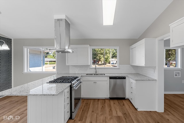 kitchen with island range hood, sink, white cabinets, light wood-type flooring, and appliances with stainless steel finishes