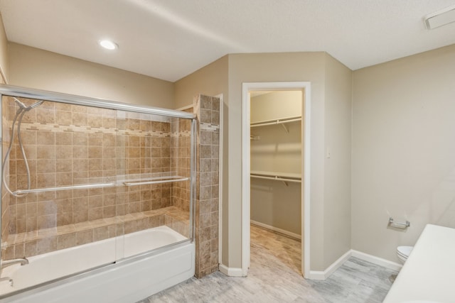 bathroom with toilet, enclosed tub / shower combo, and hardwood / wood-style floors