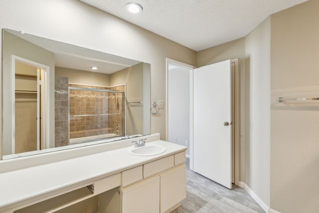 bathroom featuring vanity, wood-type flooring, and a textured ceiling