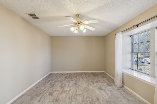 empty room featuring ceiling fan, a textured ceiling, and light wood-type flooring