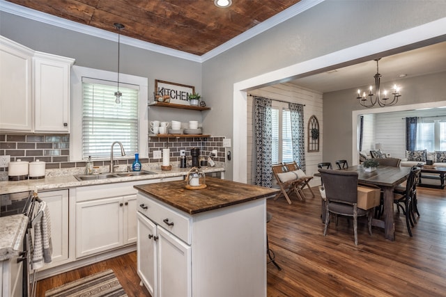 kitchen featuring a kitchen island, dark wood-type flooring, sink, pendant lighting, and white cabinets