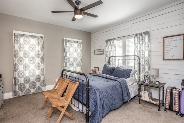 carpeted bedroom with wood walls and ceiling fan