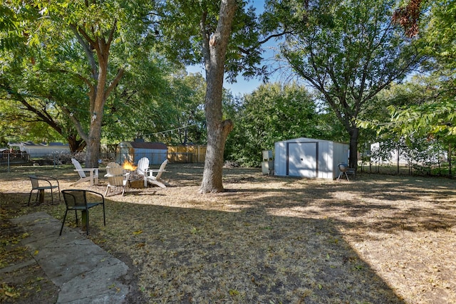 view of yard featuring a storage shed and an outdoor fire pit