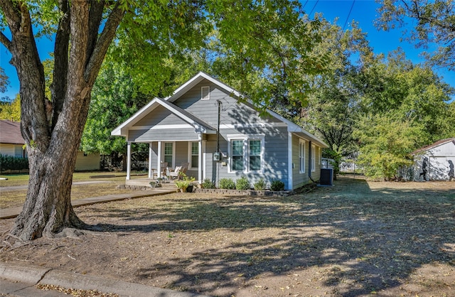 view of front of home with a storage shed, central AC, and a porch