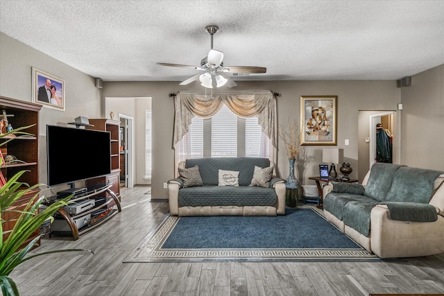 living room with ceiling fan, hardwood / wood-style floors, and a textured ceiling