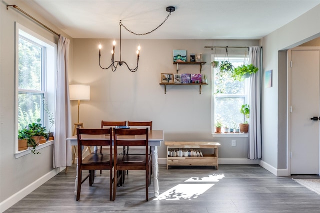 6900 Skillman St Unit 413, Dallas, TX 75231 - dining room featuring baseboards, a notable chandelier, a healthy amount of sunlight, and wood finished floors