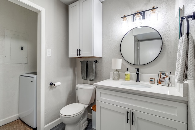 bathroom featuring toilet, washer / clothes dryer, electric panel, and vanity