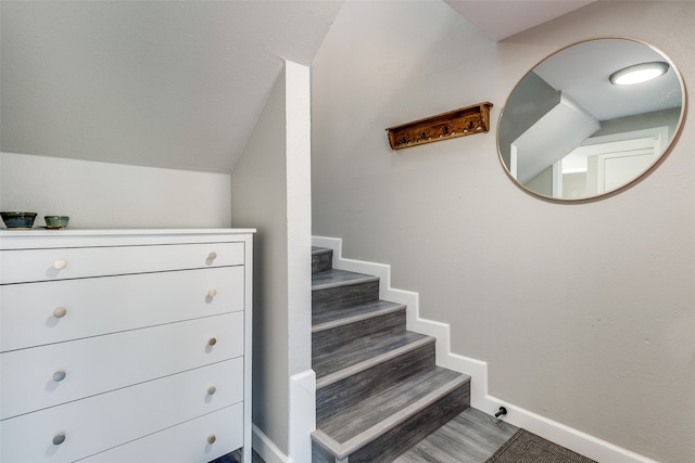 stairs featuring lofted ceiling and hardwood / wood-style floors