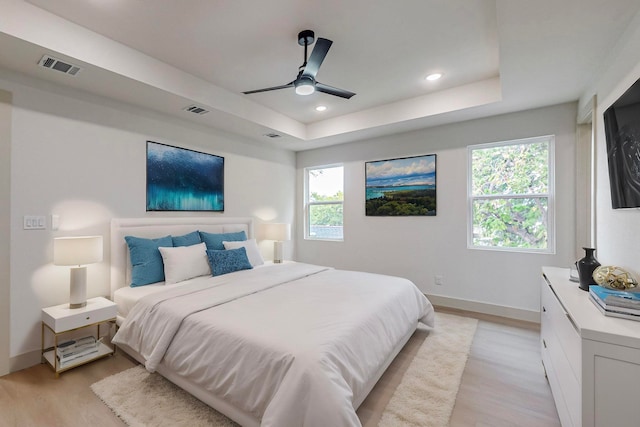 bedroom featuring multiple windows, light wood-type flooring, and ceiling fan