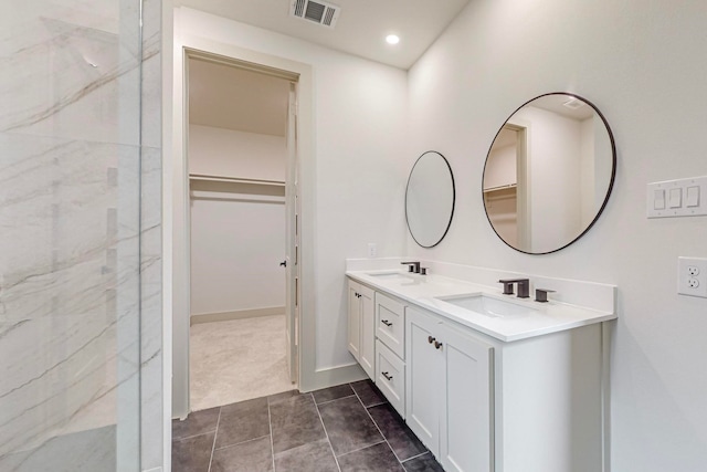 bathroom featuring vanity, tile patterned flooring, and walk in shower