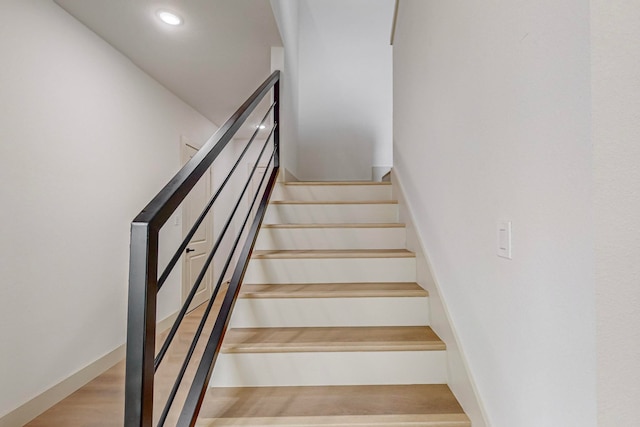 staircase with hardwood / wood-style flooring