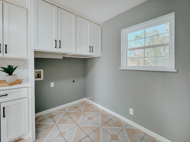 laundry room featuring washer hookup, electric dryer hookup, cabinets, and light tile patterned floors