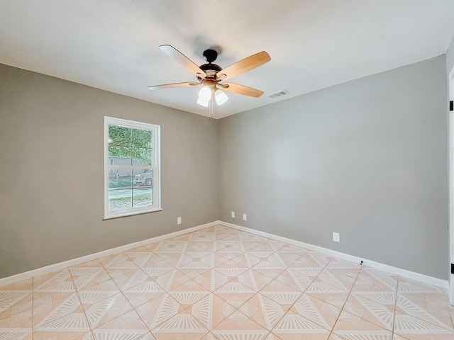 tiled spare room featuring ceiling fan