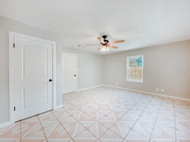 tiled empty room featuring ceiling fan